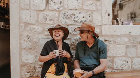 A man and a woman sitting on a bench and laughing