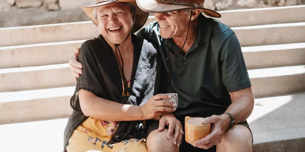 A couple laugh while sitting on some steps