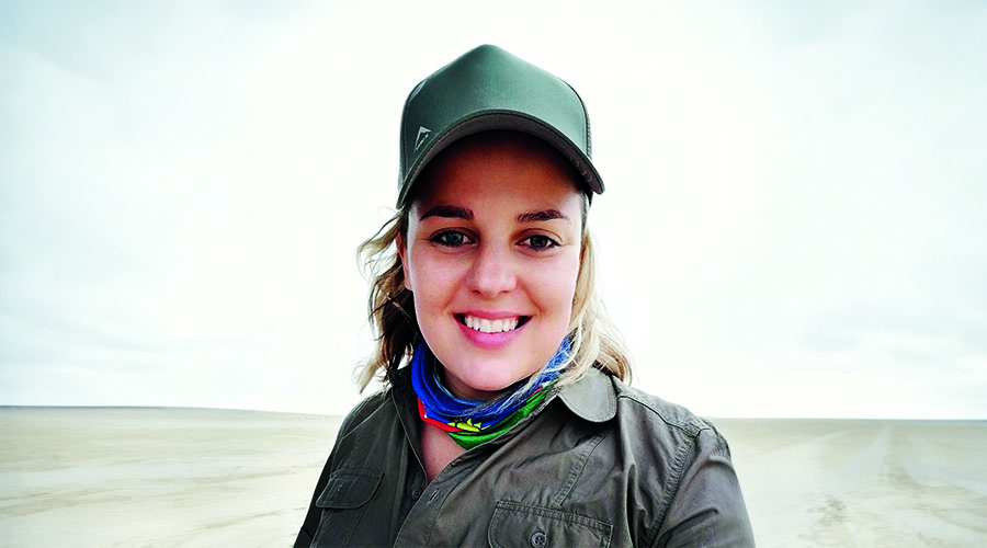 Travel Director Lana Joubert in front of sandy landscape