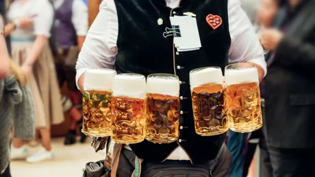 Waiter carrying beer in traditional steins