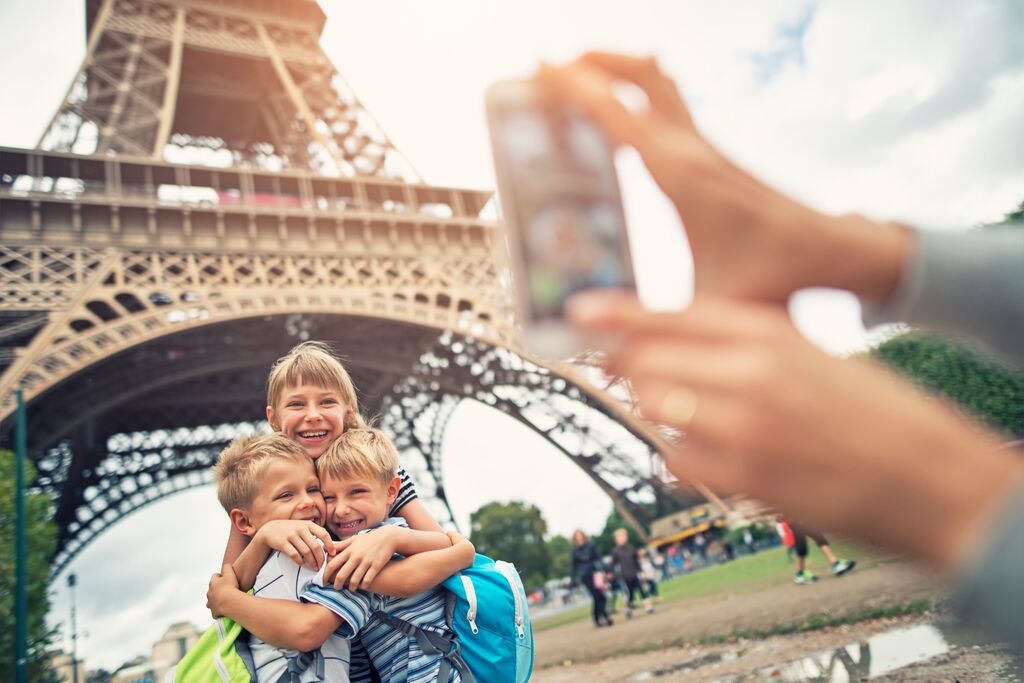 Kids Tourists Smiling At The Camera Near Eiffel Tower, Paris, France
