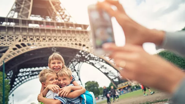 Kids Tourists Smiling At The Camera Near Eiffel Tower, Paris, France