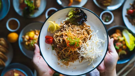 Hands holding up a dish of food