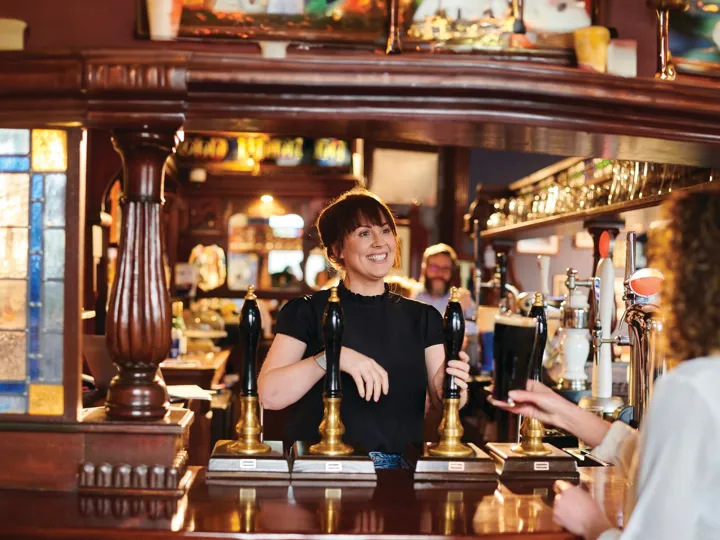 bar worker warmly greeting customer
