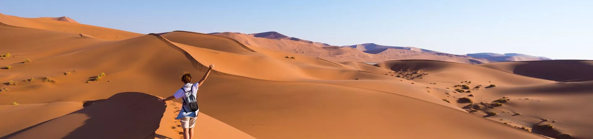 Lady walking on sand dunes in Namibia