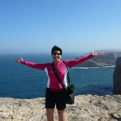 Travel Director Elaine on top of cliff over the ocean