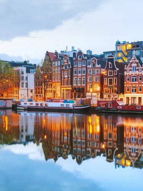 Night Amsterdam with canals and boats in The Netherlands