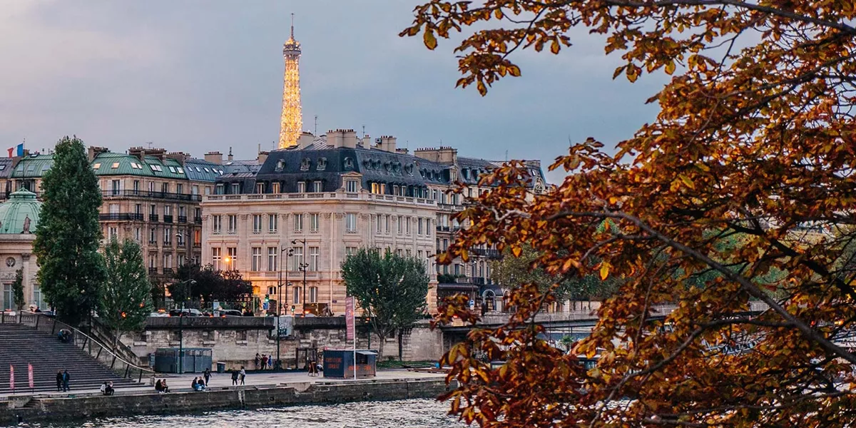 Paris at dusk during the autumn with the eiffel tower lit up in the background