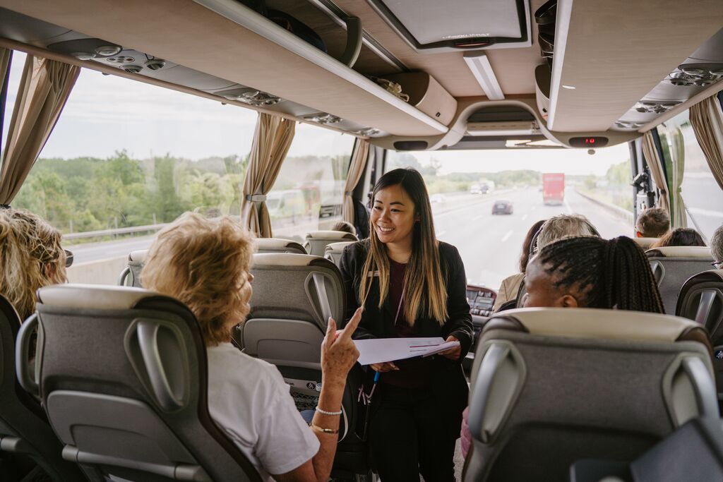 Travel Director smiling at guests on a coach