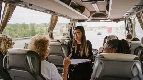 Travel Director smiling at guests on a coach