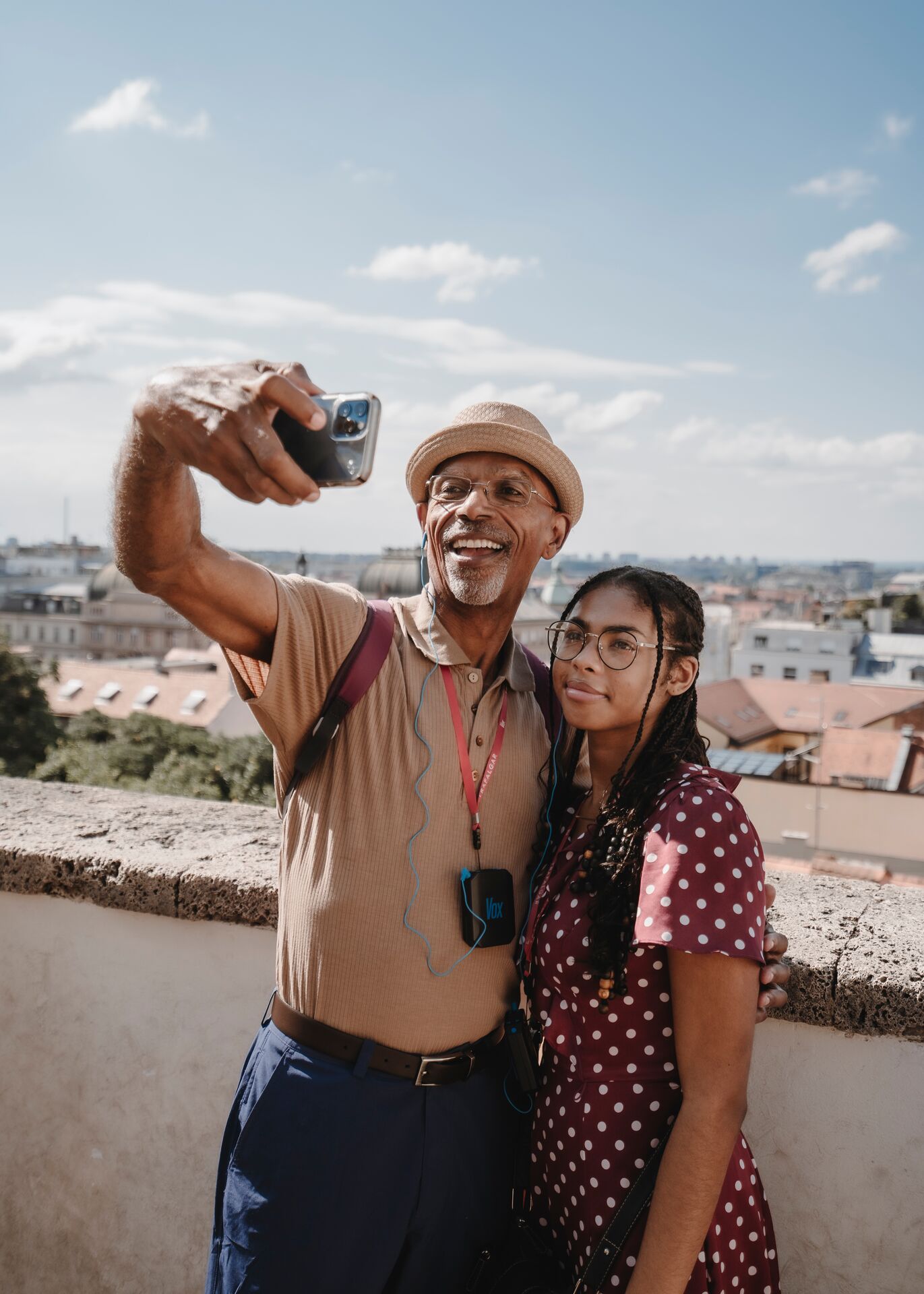 Two people taking a selfie with a city in the background
