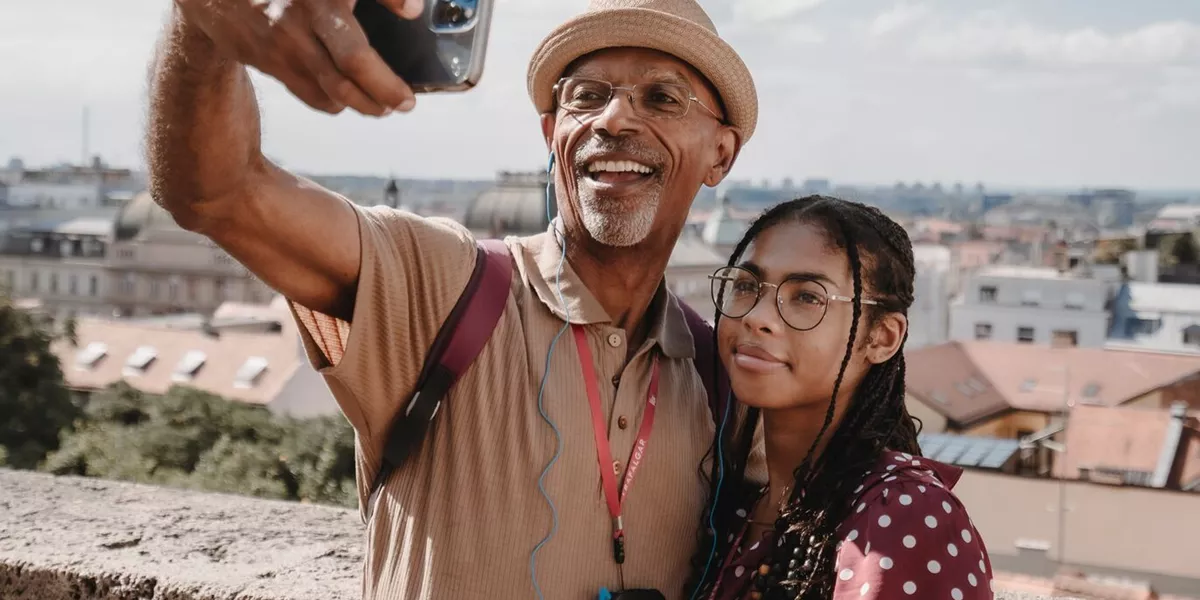 Two people taking a selfie with a city in the background