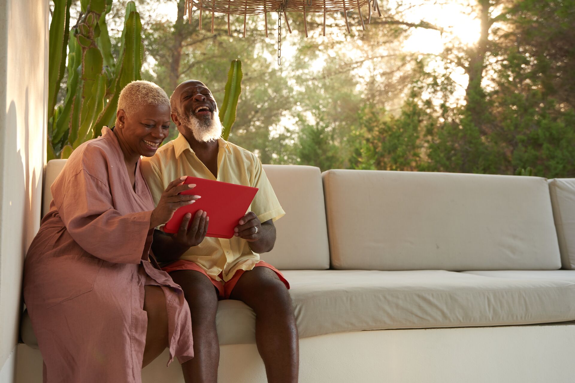 Older couple laugh with a tablet
