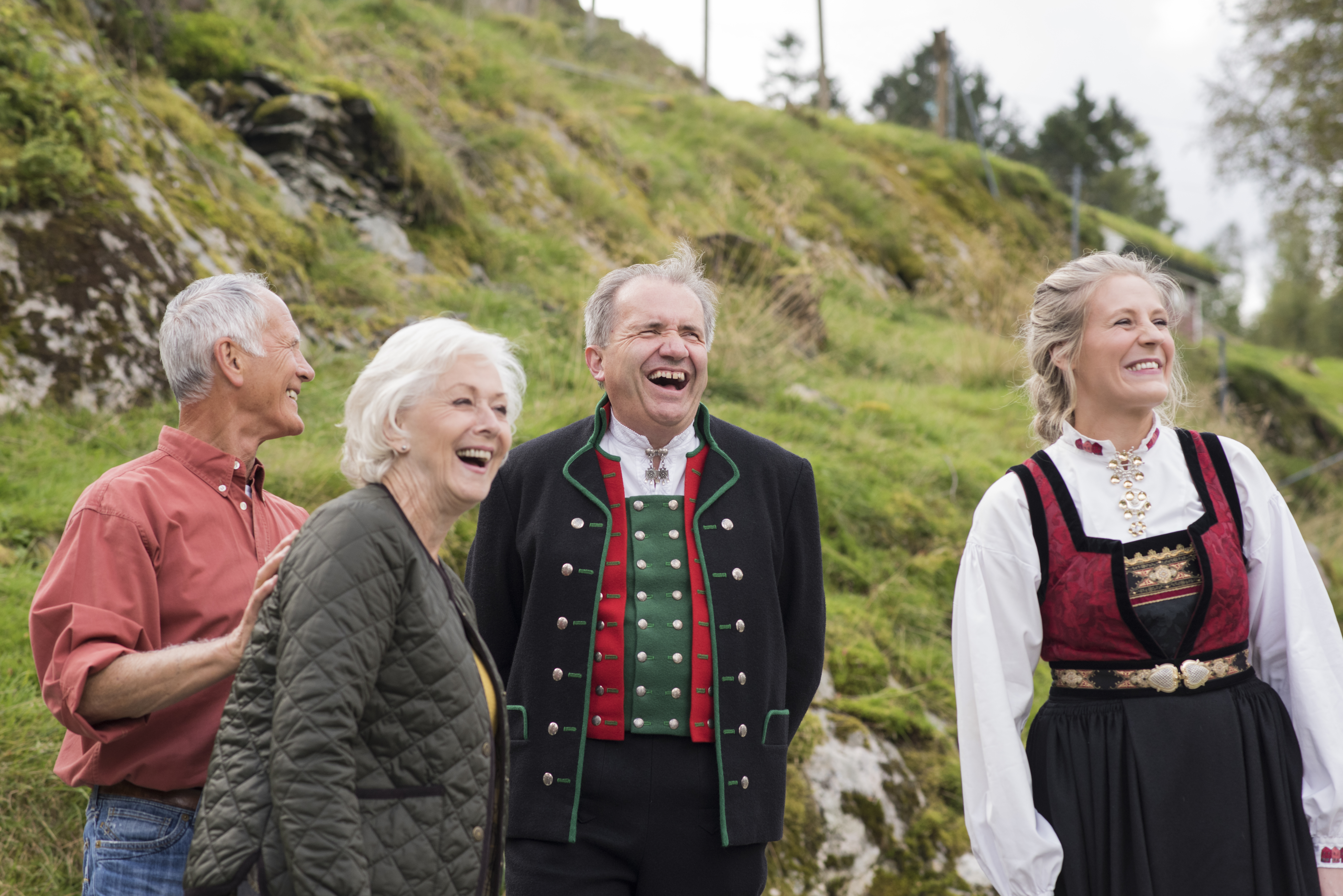 Guests accompanied by hosts wearing traditional clothing on Ovre Eide Farm in Norway