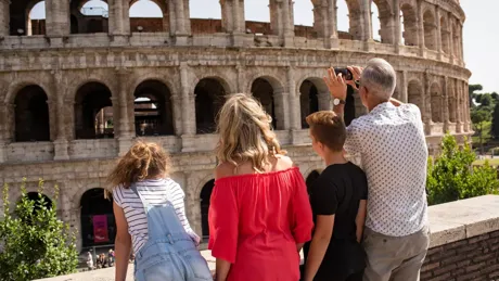 Family taking photos of the Colosseum in Rome, Italy