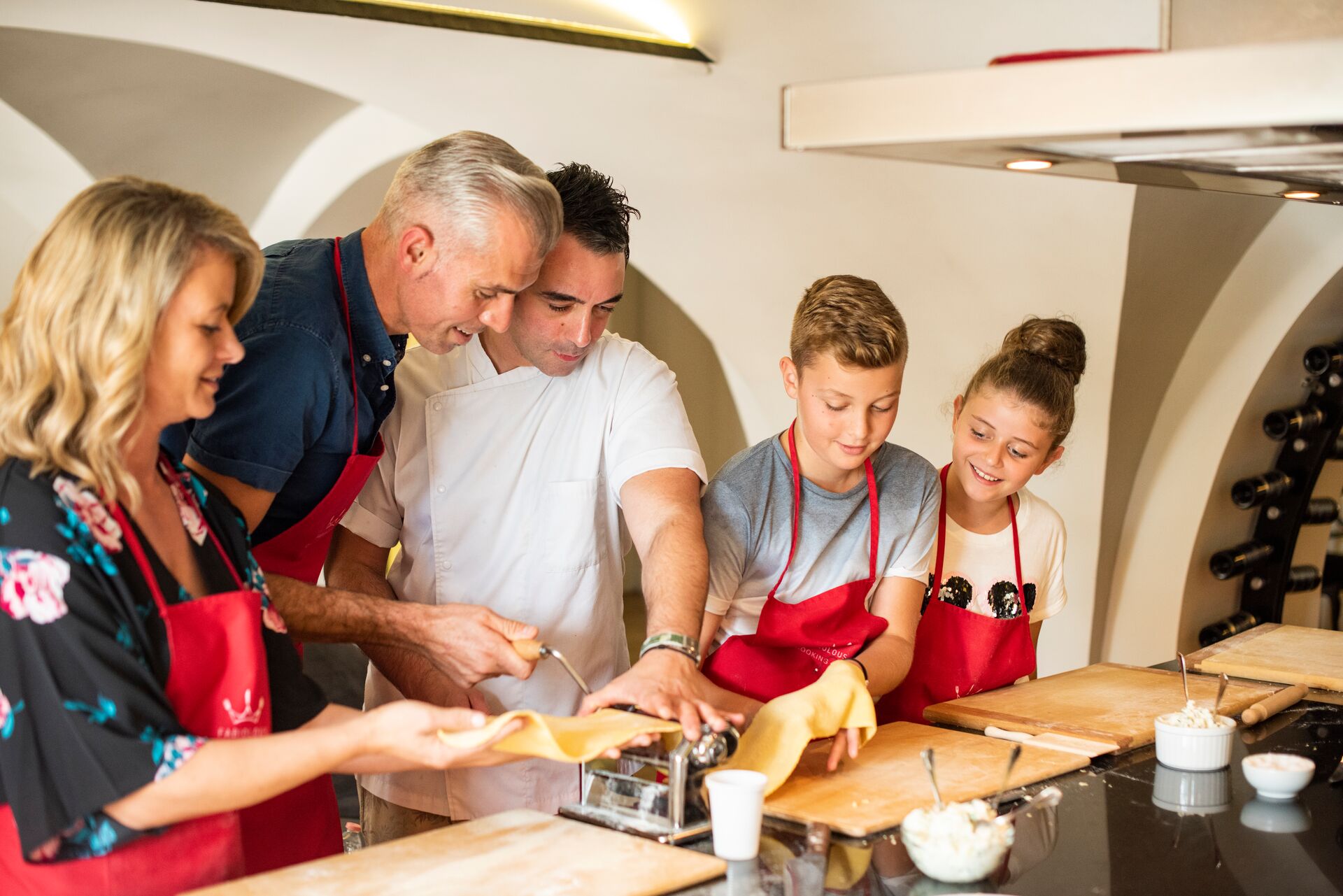 Family making pasta while on holiday in Italy