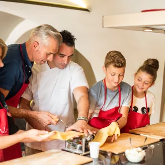 Family making pasta while on holiday in Italy