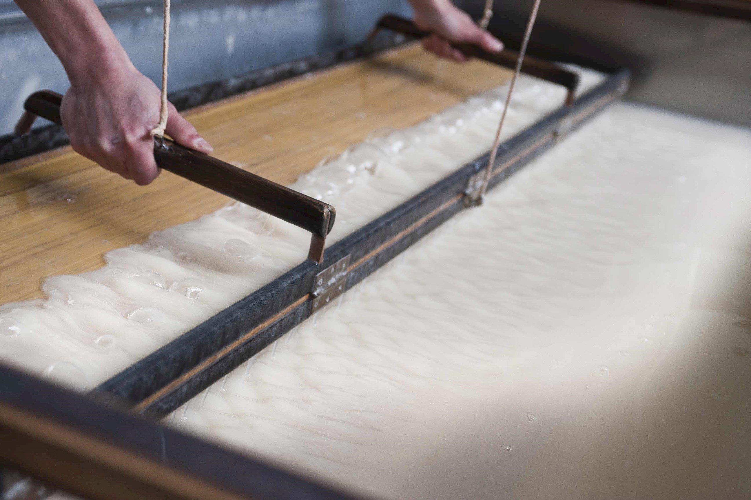 Preparing a sheet of washi paper on workshops in Gokayama, Japan