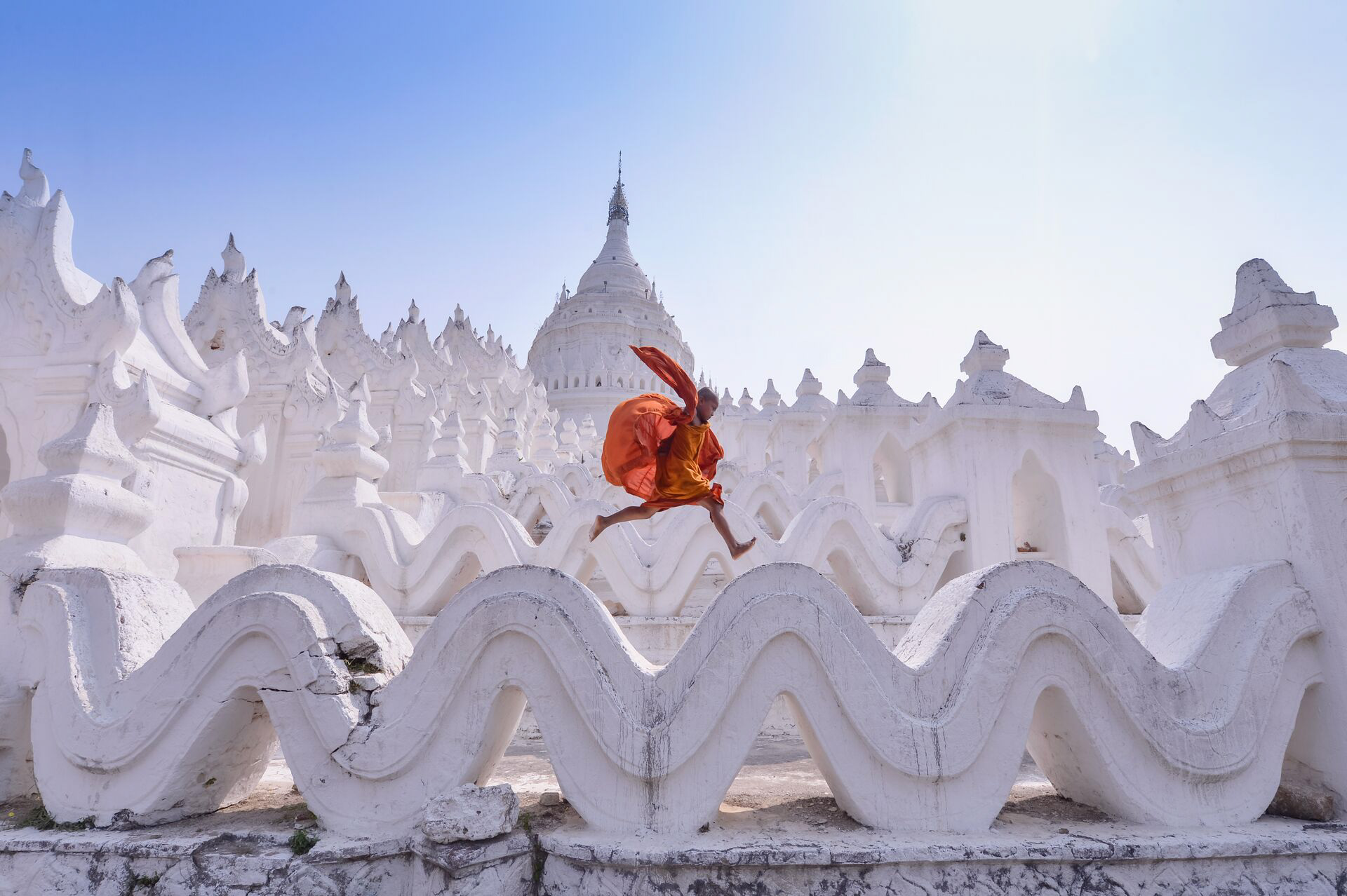 Monk jumping on walls of traditional temple in Myanmar 