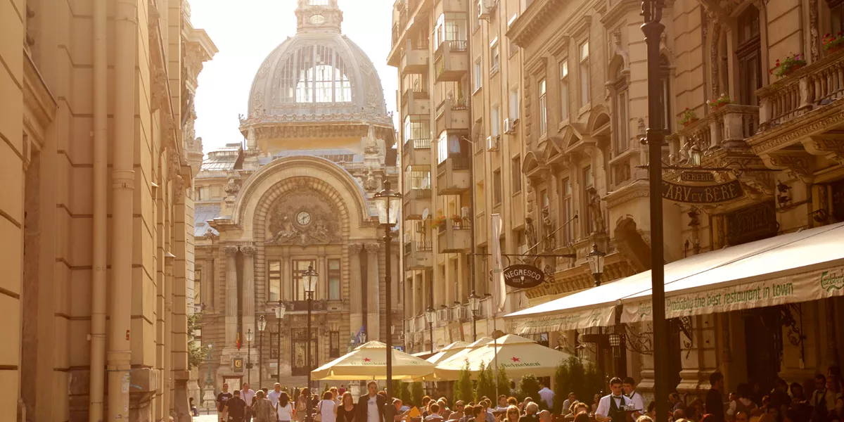 A street filled with people sitting in cafe gardens