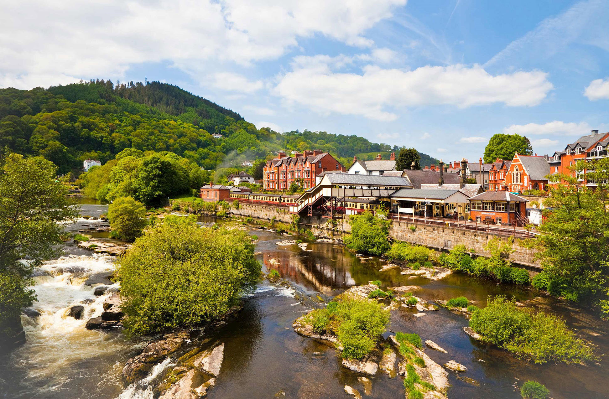 Riverside town with historic buildings and green hills in Llangollen, Wales