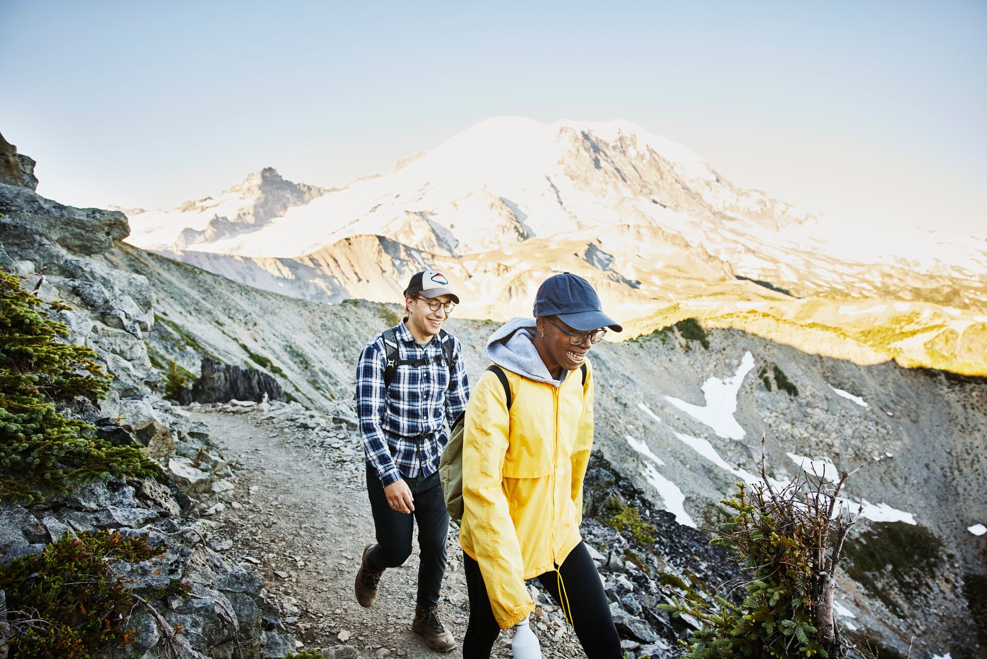 Smiling couple hiking on an Alpine trail with Mt Rainier in the background