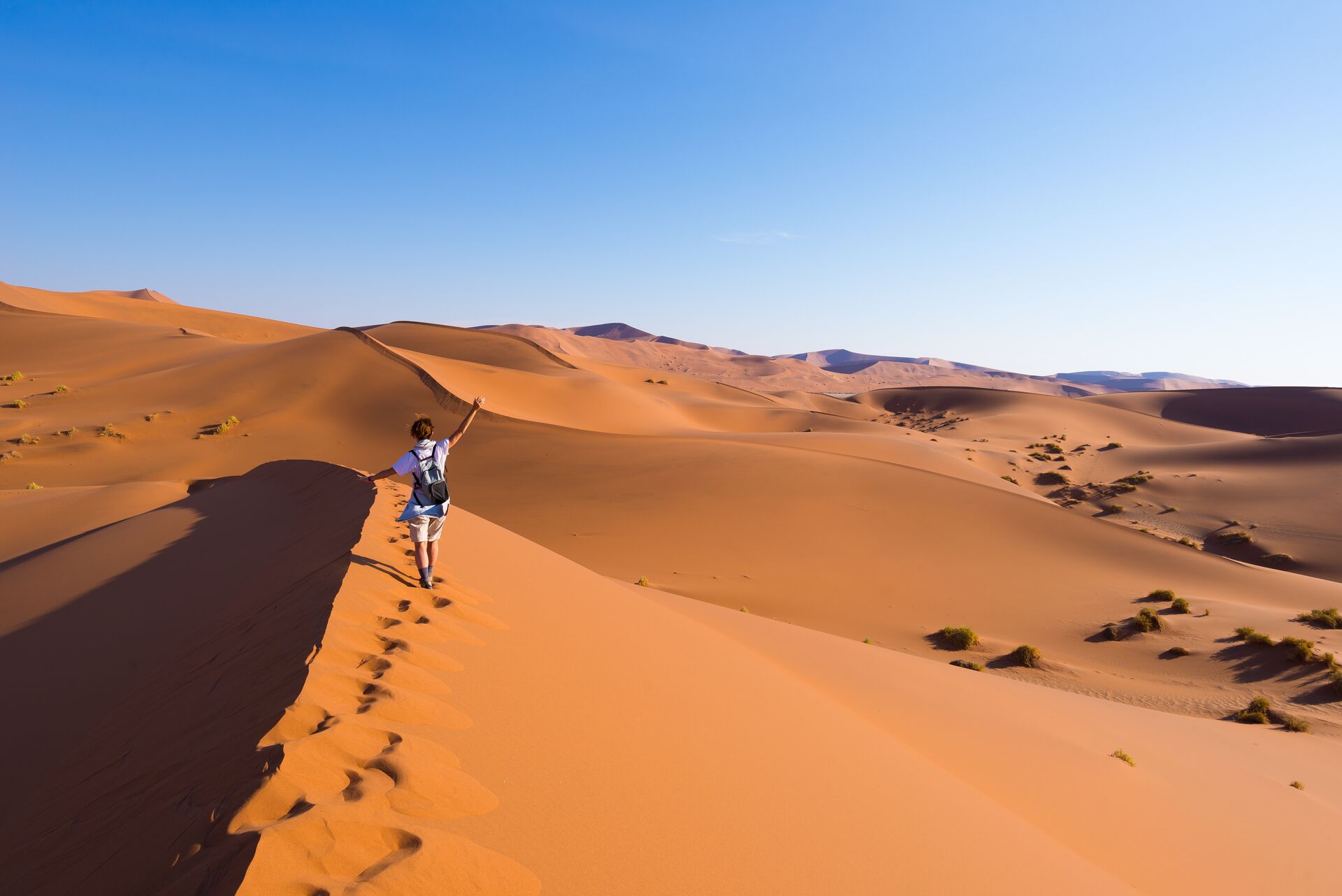 A person walking on sand dunes in Namibia, Africa