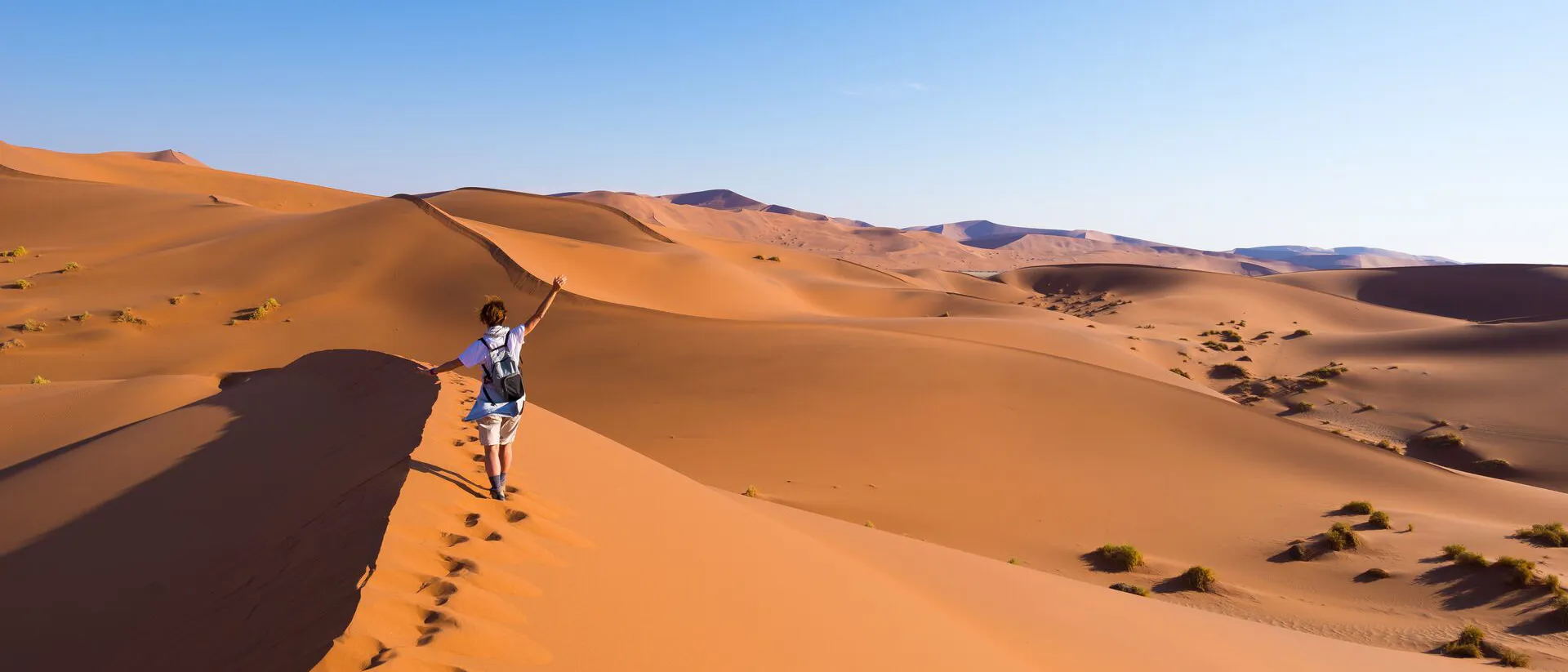 A person walking on sand dunes in Namibia, Africa