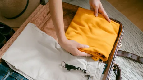 Aerial view of woman packing a suitcase