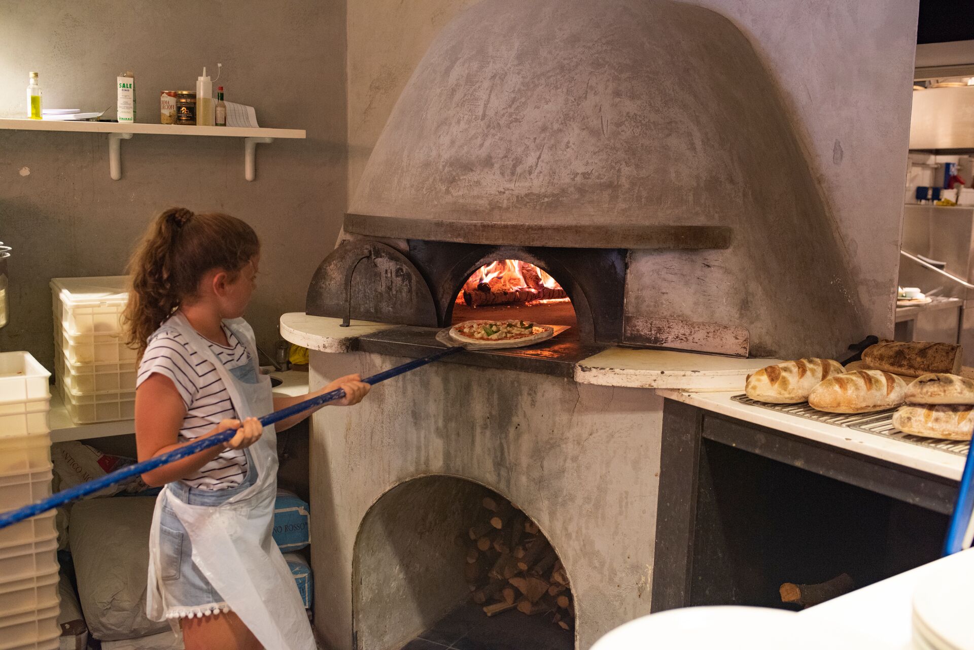 Girl cooking pizza as part of a Pizza Making Experience in Rome, Italy