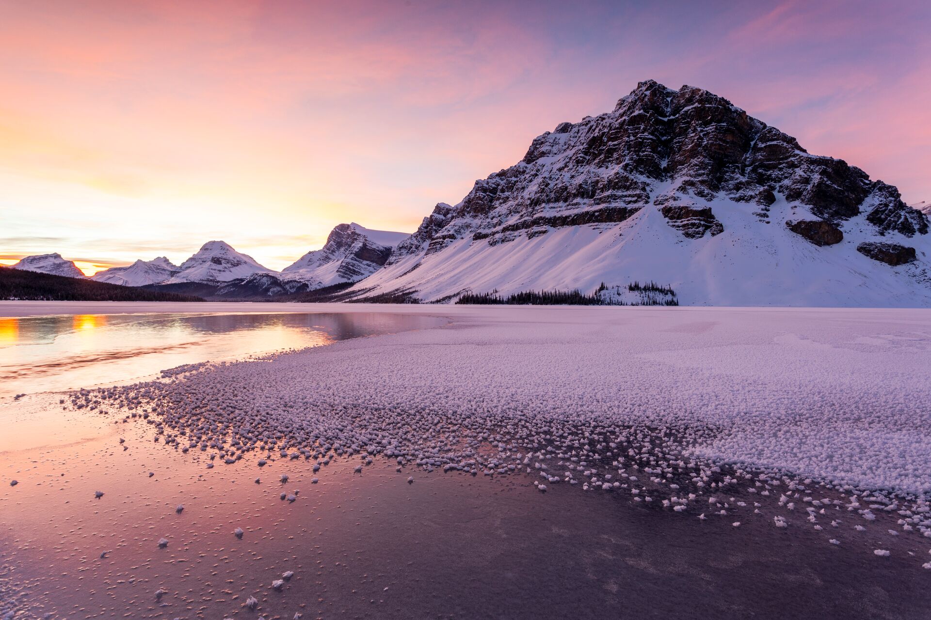 Sun rising over a frozen Bow Lake in winter in Banff National Park, Alberta, Canada