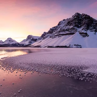 Sun rising over a frozen Bow Lake in winter in Banff National Park, Alberta, Canada