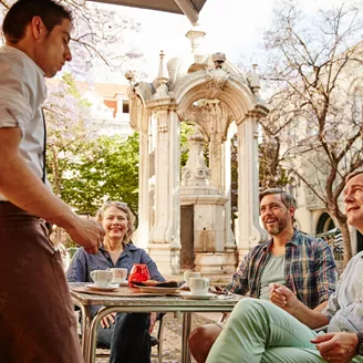 People talking to a waiter during lunch in Lisbon, Portugal