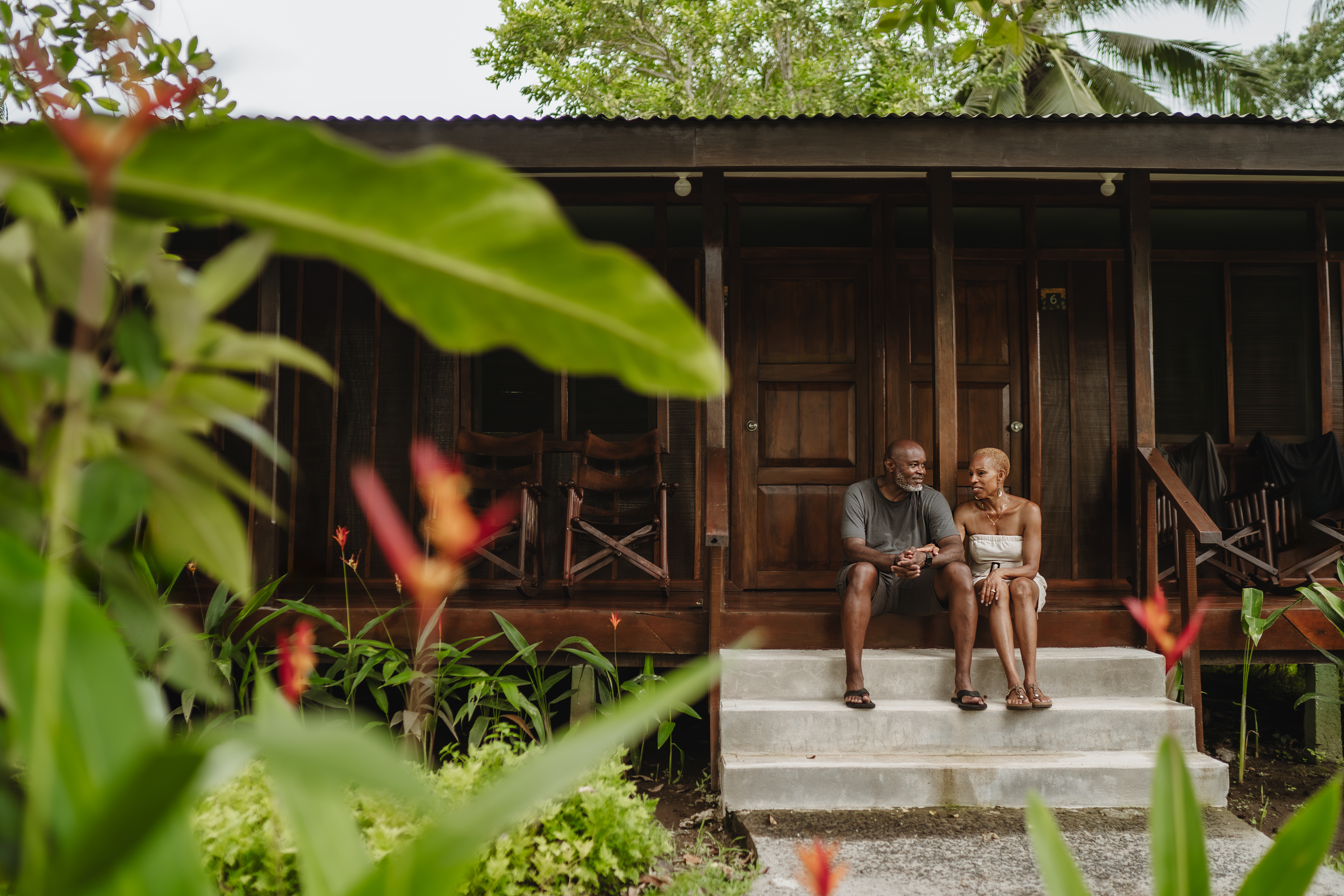 A man and woman sitting outside Laguna Lodge, Tortuguero