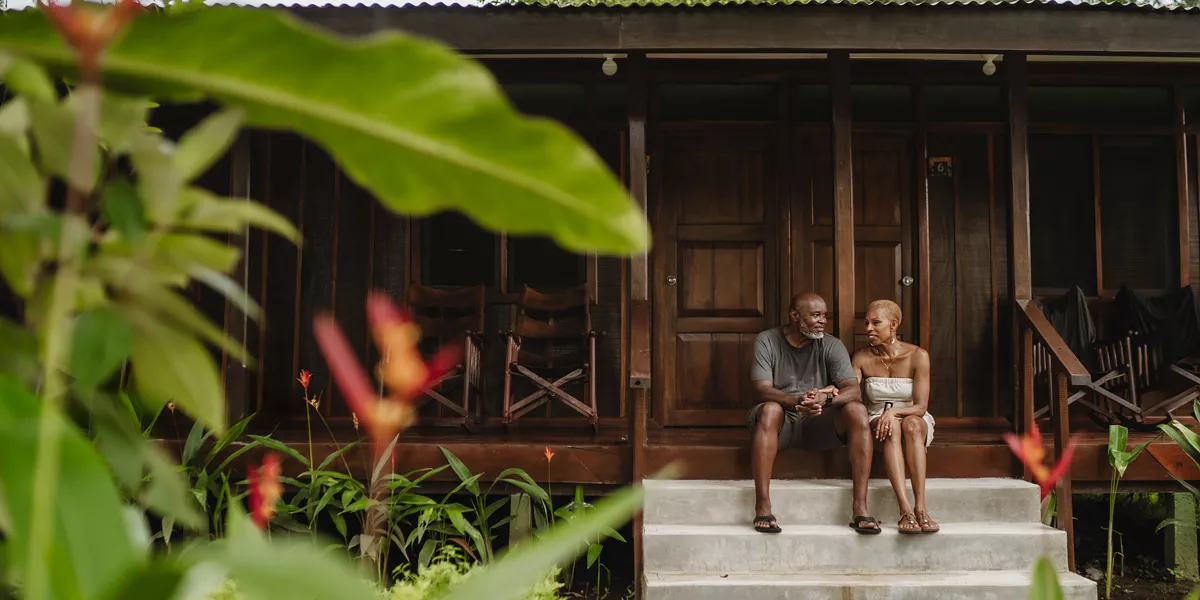 A man and woman sitting outside Laguna Lodge, Tortuguero