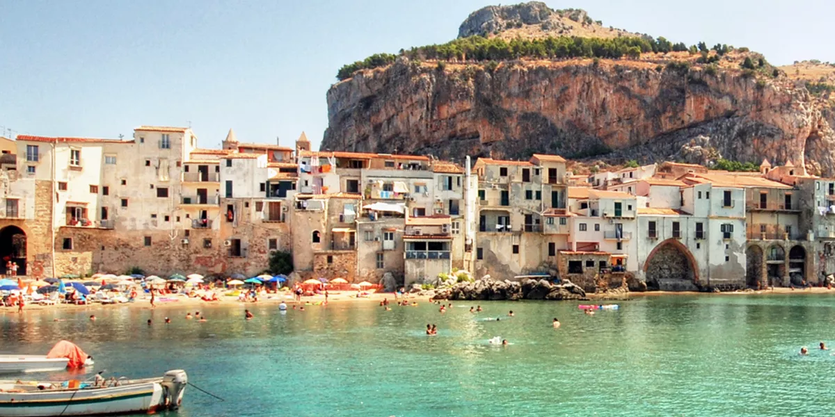 Italian coast with azure water and people swimming in it