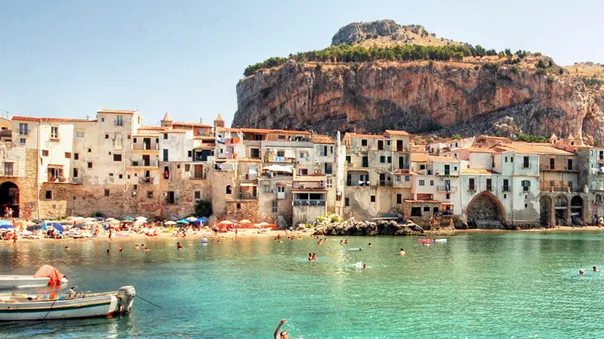 Italian coast with azure water and people swimming in it