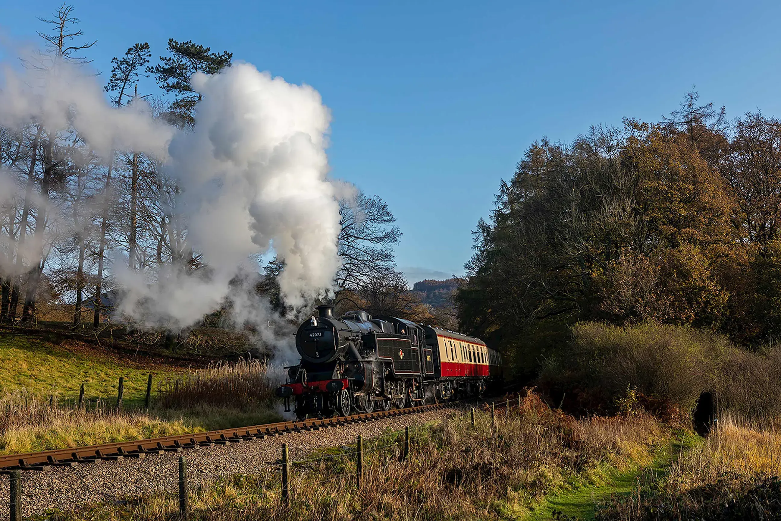 A steam train driving through the English Lake District