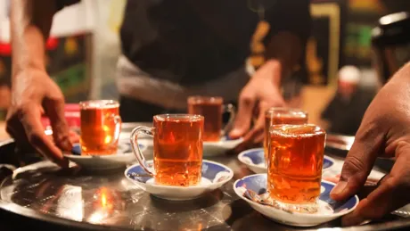 A tray of Turkish cups with tea on it