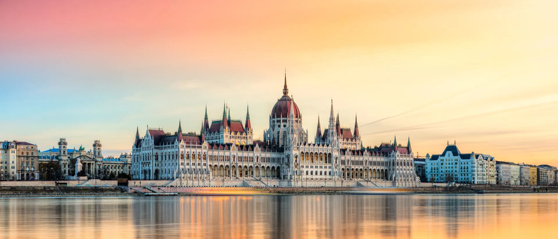 Hungarian Parliament in Budapest, reflected in a beautiful orange-hued river