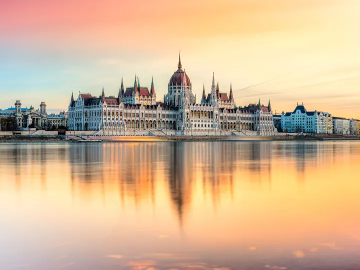 Hungarian Parliament in Budapest, reflected in a beautiful orange-hued river