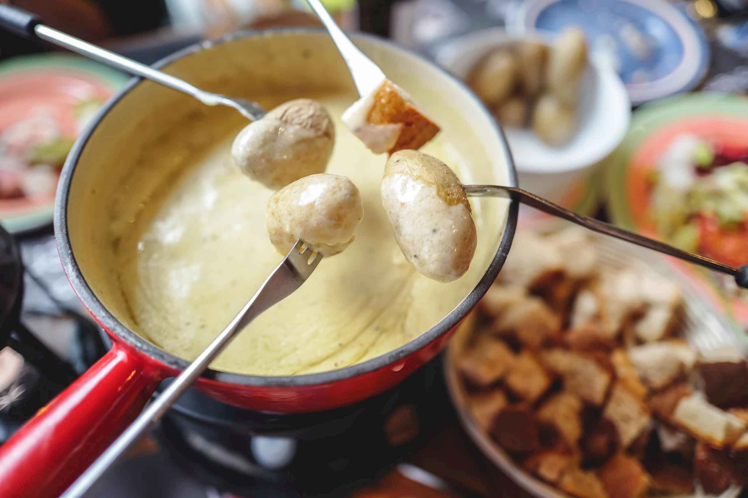 A close-up of a fondue pot full of Swiss Cheese