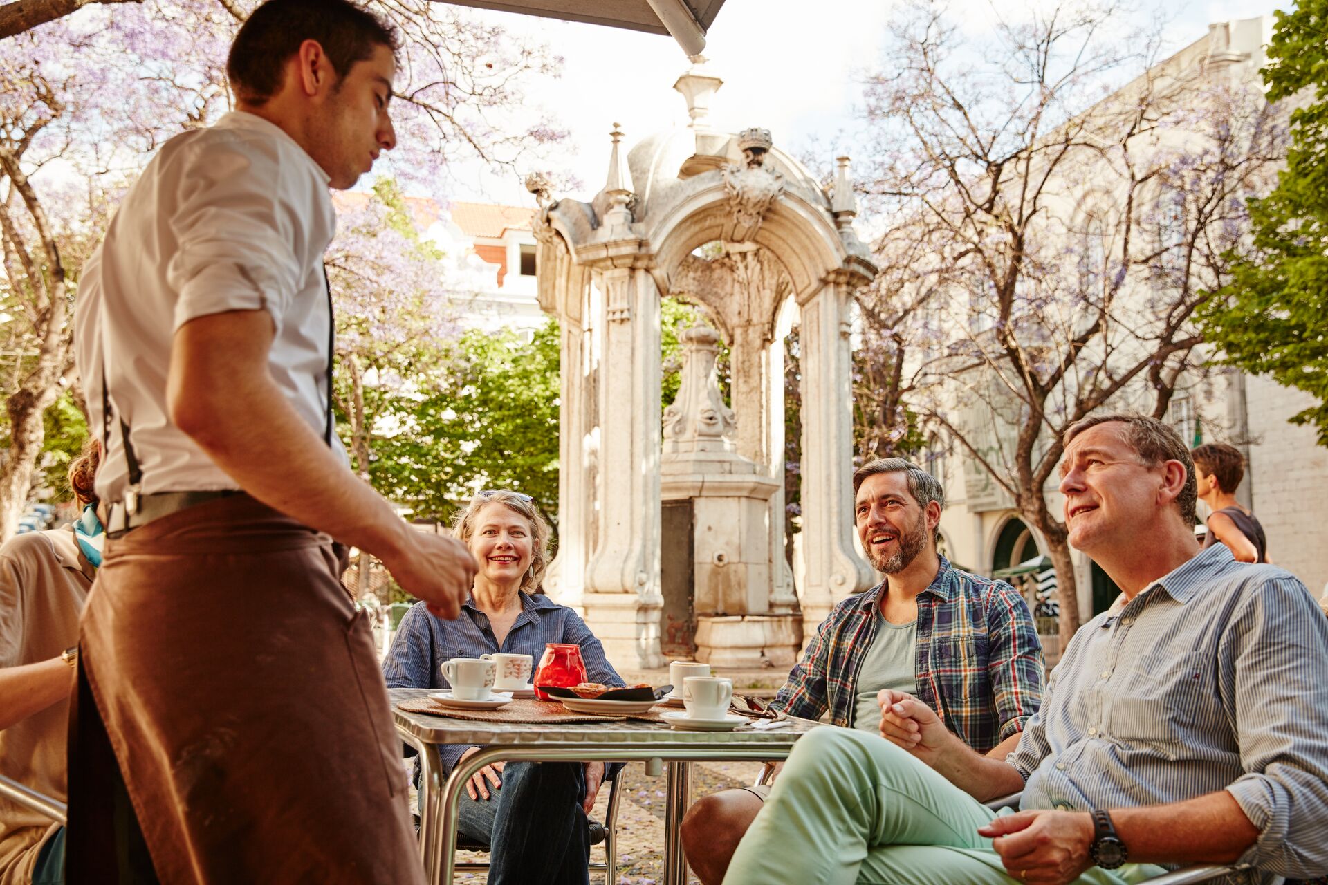 Guests talking to a waiter while in Lisbon, Portugal