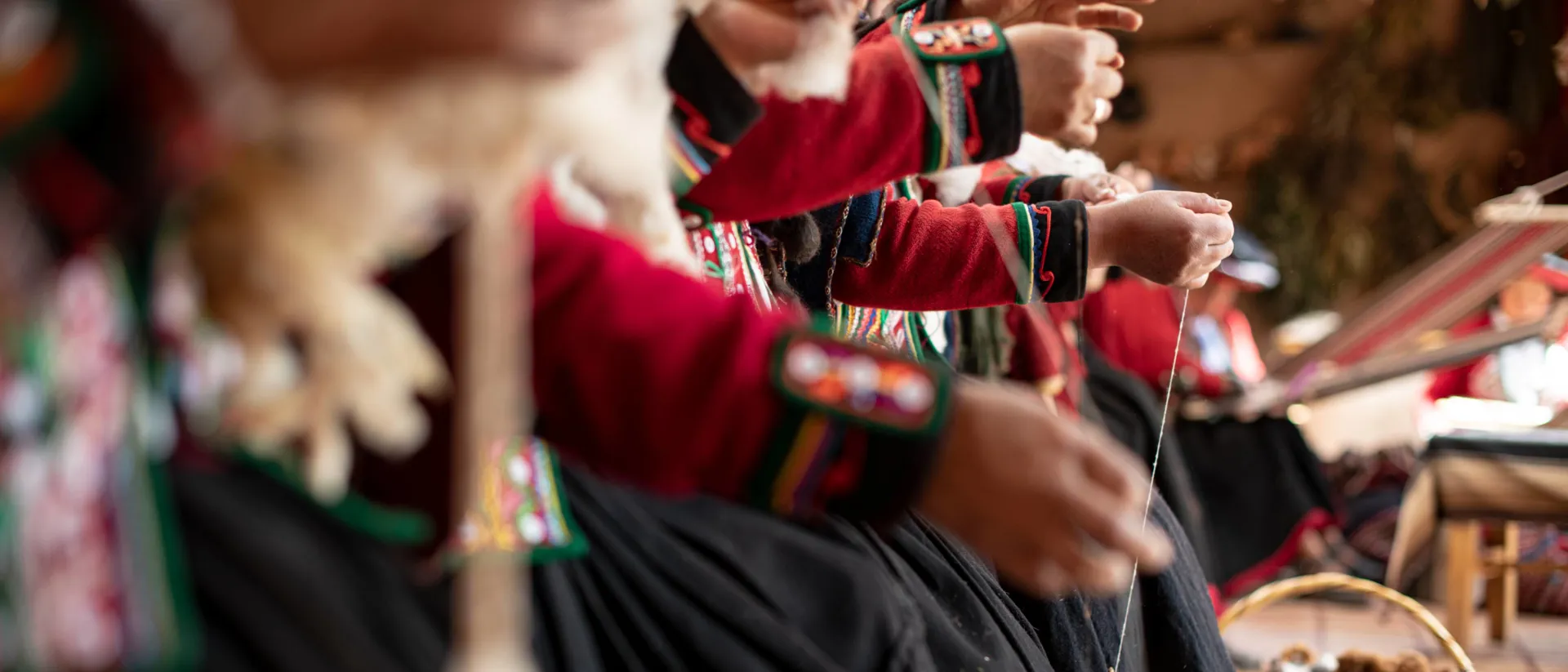 Hands of women in traditional dresses knitting
