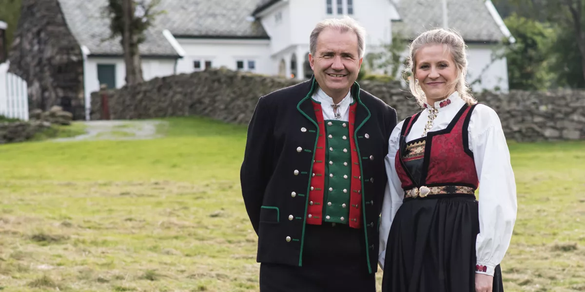 A man and woman wearing traditional clothing in Ovreeide Farm, Norway