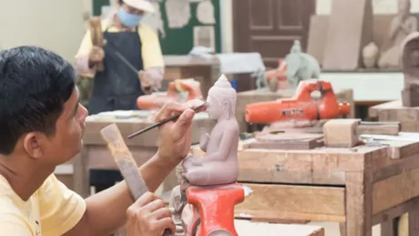 Artisan working on Buddha sculpture in Angkor Siem Reap, Cambodia