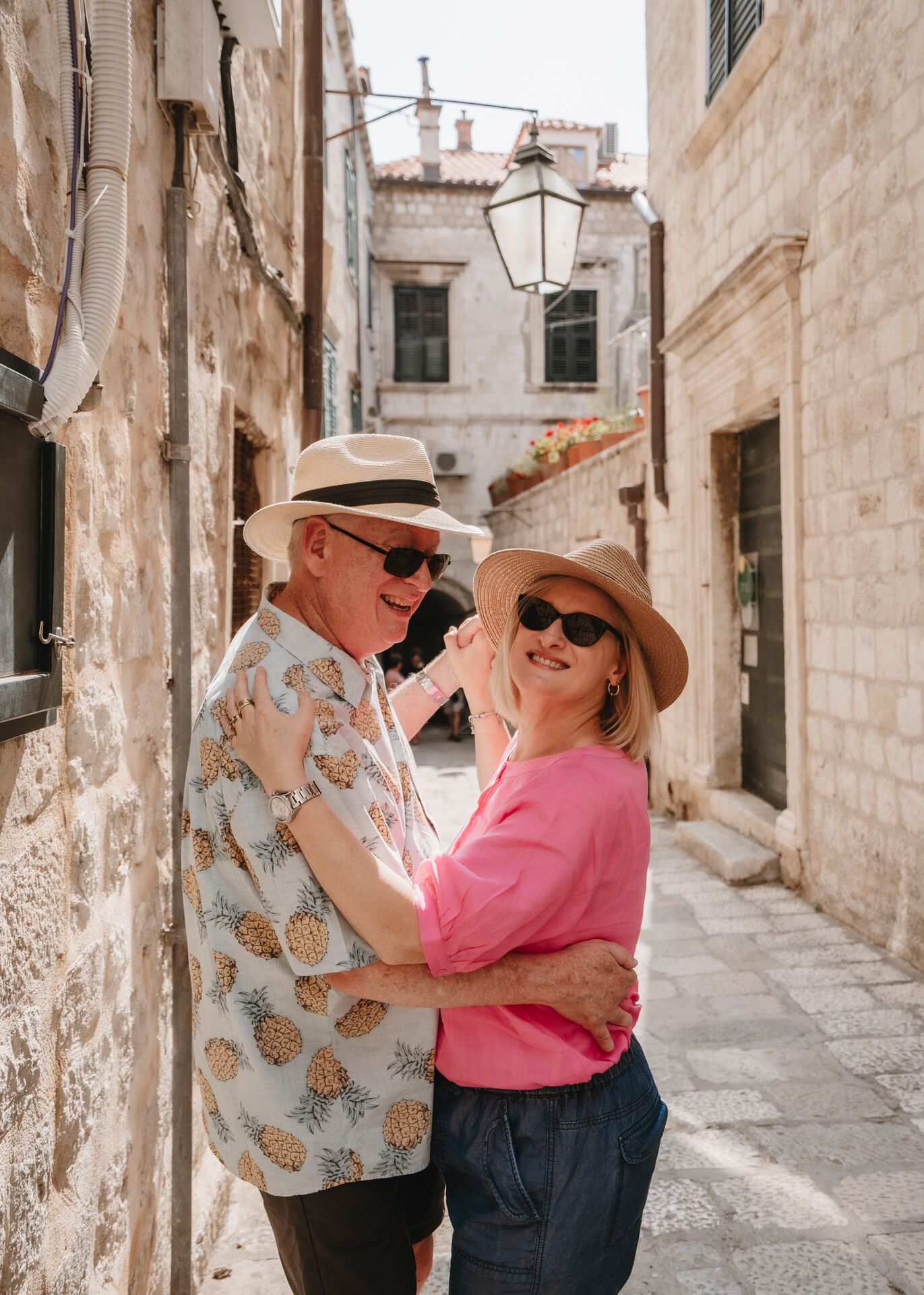 A couple dancing in a narrow street with stone buildings