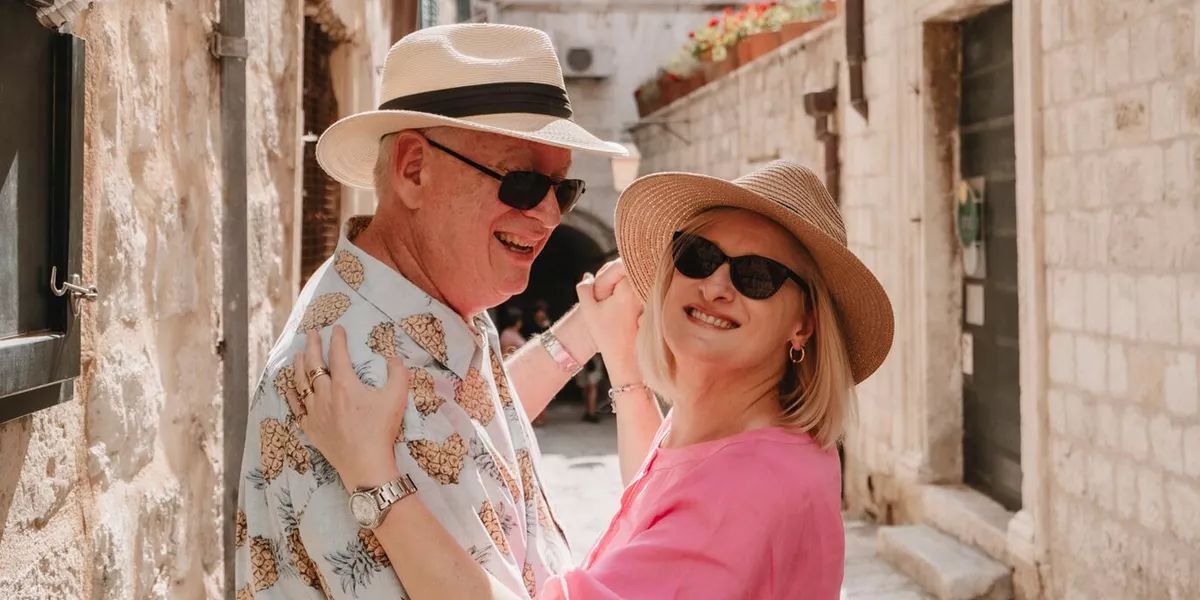 A couple dancing in a narrow street with stone buildings
