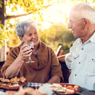 Smiling senior couple drinking wine and eating in a restaurant