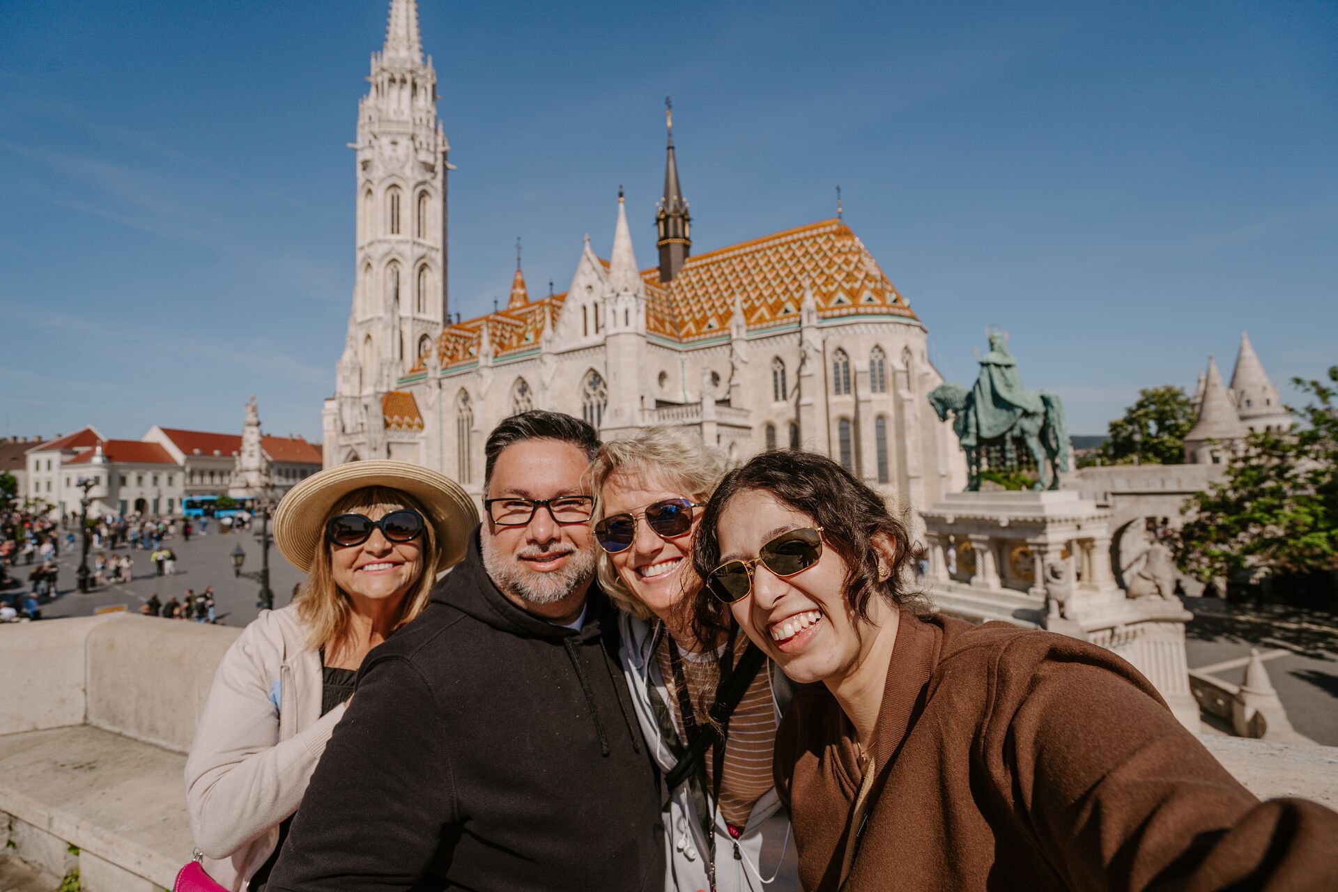 A group of smiling guests take their picture in front of a cathedral in Budapest